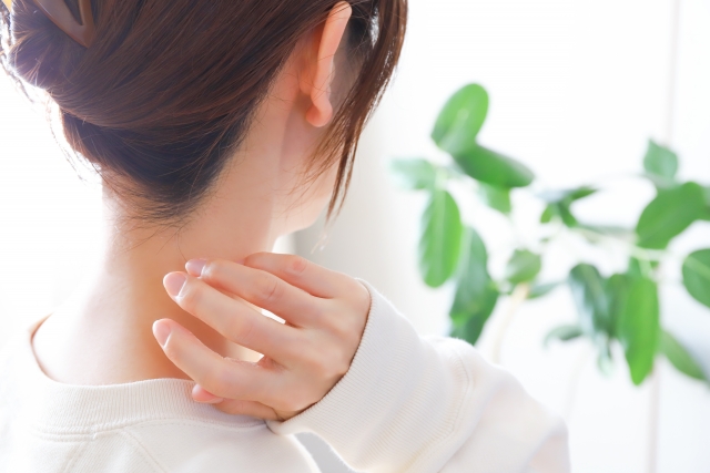 うなじを気にする女性の後ろ姿