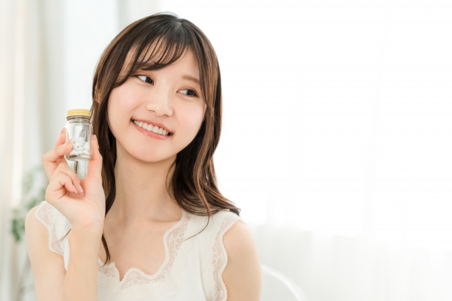 薬の瓶を持って微笑む女性